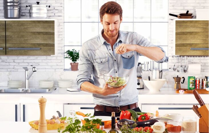 man prepares vegetable salad to increase strength